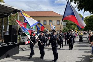 Hasiči nesou vlajky v čele slavnostního průvodu