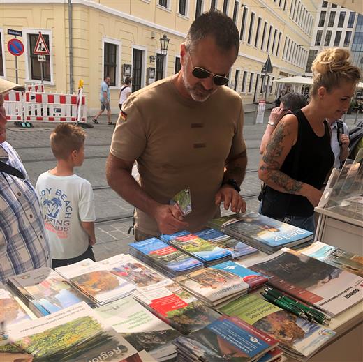 Návštěvník si prohlíží tiskoviny lákající do Ústeckého kraje