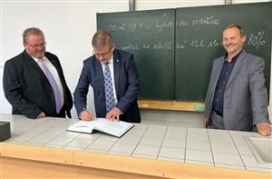 Hejtman Schiller se podepsal do pamětní knihy školy, vpravo místostarosta Podbořan Karel Honzl